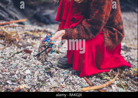 Une jeune femme est le nettoyage des ordures en plastique sur la plage Banque D'Images