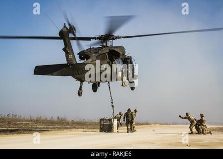 L'armée américaine et de soldats portugais, attribué à Bataille multinationales Group-East l'avant poste de commandement, conduite des opérations de charge avec un UH-60 Black Hawk piloté par des soldats de l'armée américaine, d'MNBG-Est Sud de poste de commandement, le Camp Bondsteel, au Kosovo, le 16 février. La formation avait pour but de familiariser les soldats de la Force du Kosovo avec l'élingue véhicule loading la formation, qui sera effectuée à une date ultérieure. La formation faisait partie de la mission de fournir un environnement sûr et sécuritaire à l'intérieur du Kosovo. Banque D'Images