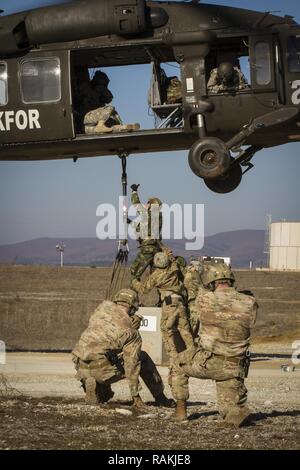 L'armée américaine et de soldats portugais, attribué à Bataille multinationales Group-East l'avant poste de commandement, conduite des opérations de charge avec un UH-60 Black Hawk piloté par des soldats de l'armée américaine, d'MNBG-Est Sud de poste de commandement, le Camp Bondsteel, au Kosovo, le 16 février. Le but de la formation était de simuler la livraison de fournitures nécessaires aux troupes au front et à continuer d'assurer un environnement sûr et sécuritaire dans le cadre de force au Kosovo. Banque D'Images
