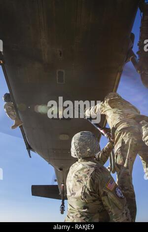 Les soldats de l'armée américaine, attribué à Bataille multinationales Group-East l'avant poste de commandement, conduite des opérations de charge avec un UH-60 Black Hawk piloté par des soldats de l'armée américaine, d'MNBG-Est Sud de poste de commandement, le Camp Bondsteel, au Kosovo, le 16 février. Les soldats de l'armée américaine a effectué l'entraînement aux côtés de leurs homologues de l'OTAN portugais dans le cadre de leur mission de fournir un environnement sûr et sécuritaire à l'intérieur du Kosovo. Banque D'Images