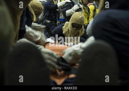 Océan Atlantique (fév. 14, 2017) marins traiter un accident personnel simulées dans le hangar de la baie le porte-avions USS Dwight D. Eisenhower (CVN 69) (Ike) au cours d'un exercice général quarts. Ike est actuellement à des qualifications d'un porte-avions au cours de la phase de maintien en puissance de la flotte (Plan d'intervention optimisés OFRP). Banque D'Images