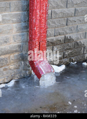 Gouttière Gouttière, congelé. Tuyau de descente, gouttière, Maison des murs de fondation gèlent parfois dans des blocs solides de glace. Mauvais nettoyage de gouttière. Banque D'Images