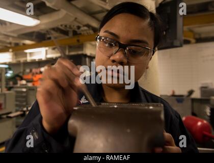 BREMERTON, Washington (fév. 17, 2017) 3ème classe technicien d'entretien des coques Lora Yosino, de Garapan, Saipan, fichiers metal mjrb off un support à bord du USS JOHN C. STENNIS (CVN 74). John C. Stennis mène une disponibilité progressive prévue (PIA) au chantier naval de Puget Sound et l'Installation de maintenance de niveau intermédiaire, au cours de laquelle le navire est soumis à des activités de maintenance et de mise à niveau. Banque D'Images