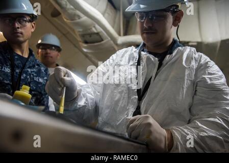 BREMERTON, Washington (fév. 17, 2017) l'Aviation maître de Manœuvre (Équipement) Airman Bradley Turner, de Miami, s'applique de la colle sur un anneau d'étanchéité du tuyau avant de le joindre à un raccord de tuyau à l'escadron dans un bureau d'entretien à bord du USS JOHN C. STENNIS (CVN 74). John C. Stennis mène une disponibilité progressive prévue (PIA) au chantier naval de Puget Sound et l'Installation de maintenance de niveau intermédiaire, au cours de laquelle le navire est soumis à des activités de maintenance et de mise à niveau. Banque D'Images