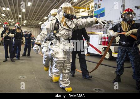 SASEBO, Japon (fév. 24, 2017) Ministère de l'Air combat marins une simulation d'incendie d'aéronefs dans la zone d'assaut amphibie USS Bonhomme Richard (DG 6). Bonhomme Richard, l'avant-déployé à Sasebo, au Japon, est au service de l'avant pour avoir une capacité d'intervention rapide en cas de catastrophe naturelle ou d'urgence régionaux. Banque D'Images