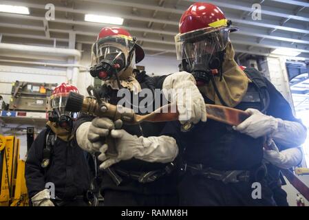 SASEBO, Japon (fév. 24, 2017) Ministère de l'Air combat marins une simulation d'incendie d'aéronefs dans la zone d'assaut amphibie USS Bonhomme Richard (DG 6). Bonhomme Richard, l'avant-déployé à Sasebo, au Japon, est au service de l'avant pour avoir une capacité d'intervention rapide en cas de catastrophe naturelle ou d'urgence régionaux. Banque D'Images