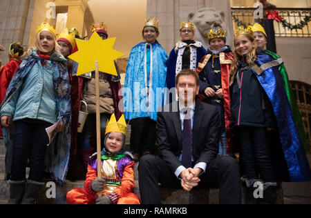 Dresde, Allemagne. 08Th Jan, 2019. Michael Kretschmer (CDU), premier ministre de Saxe, est assis sur un escalier au cours de la visite de l'étoile chanteurs de la chancellerie d'État saxon entourés d'enfants. Les 120 filles et garçons du diocèse Dresden-Meißen apporter la bénédiction de Dieu au peuple dans les premiers jours de l'année et recueillir des dons pour les enfants dans le besoin. Credit : Monika Skolimowska/dpa-Zentralbild/dpa/Alamy Live News Banque D'Images