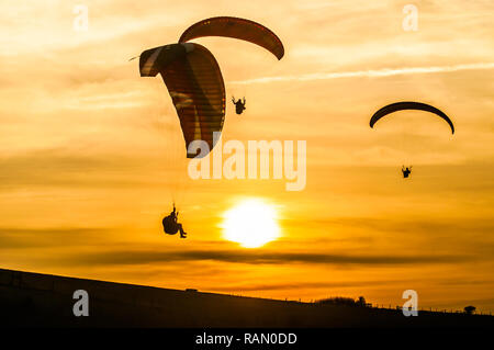 Firle, Lewes, East Sussex, Royaume-Uni. 4 janvier 2019. Parapente dans la brise Du Nord pendant que le soleil descend au-dessus des South Downs. Banque D'Images