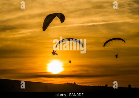 Firle, Lewes, East Sussex, Royaume-Uni. 4 janvier 2019. Parapente dans la brise Du Nord pendant que le soleil descend au-dessus des South Downs. Banque D'Images