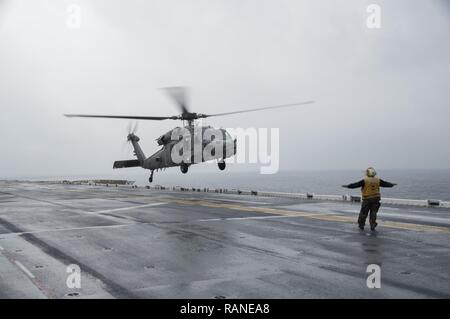 Mer des Philippines (1 mars 2017) l'Aviation maître de Manœuvre (manutention) Airman Nyshel Pease, de Colville, Wash., signe d'un MH-60S Sea Hawk, affecté à l'Escadron d'hélicoptères de combat de la mer (HSC), 25 pour l'atterrissage à bord du navire d'assaut amphibie USS Bonhomme Richard (DG 6). Bonhomme Richard est sur une patrouille de routine, opérant dans la région du Pacifique-Indo-Asia pour servir d'avant-capacité pour n'importe quel type d'éventualité. Banque D'Images