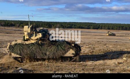 Un peloton de U.S. M3A2 Bradley La lutte contre les véhicules affectés au 4ème escadron, 10e Régiment de cavalerie (Black Jack), 3ème Armored Brigade Combat Team, 4e Division d'infanterie, se déplacer à travers méthodiquement le terrain découvert pour occuper leurs positions de combat au cours d'un exercice d'armes de la moissonneuse-batteuse Live-Fire Mar. 1, 2017. L'Atlantique, l'opération dirigée par l'américain en Europe de l'Est qui démontre l'engagement des États-Unis à la sécurité collective de l'OTAN et son dévouement à la paix durable et la stabilité dans la région. Banque D'Images