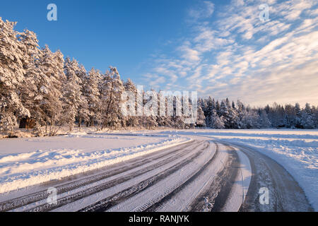 Paysage d'hiver avec une route de glace et journée ensoleillée en Finlande Banque D'Images