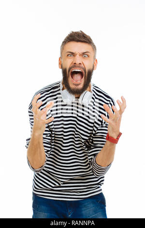 Beau jeune homme exprimant son émotion de colère Banque D'Images