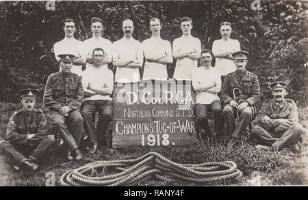 Vintage Carte postale photographique montrant des soldats britanniques WW1. La compagnie a, 'D' R.G.A. Northern Command S.T.D. Le remorqueur de guerre 1918 Champions. Banque D'Images