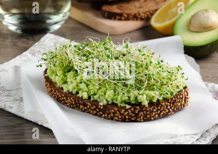 Sandwich de tendre, juteuse et luzerne germées germes d'avocat sur les tranches de pain de seigle avec des céréales. C'est une excellente idée pour ceux qui regardent leurs h Banque D'Images