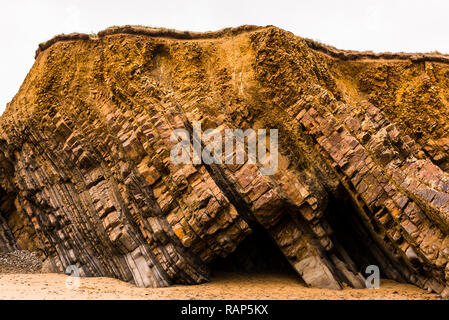 Les strates de roche en pente sur les falaises de Widemouth Bay, Cornwall, UK Banque D'Images