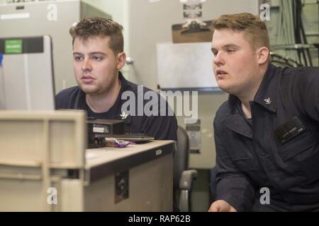 Golfe Arabique (fév. 22, 2017) Fire Controlman 2e classe Brett Brown, à gauche, et d'incendie 3e classe Controlman Austin Mason, droite, revoir le Receiver-Programr Radar SPY-1 à bord de l'entretien de la classe Arleigh Burke destroyer lance-missiles USS Cole (DDG 67). Cole est déployée dans la zone 5e flotte américaine des opérations à l'appui d'opérations de sécurité maritime visant à rassurer les alliés et les partenaires, de préserver la liberté de navigation et de libre-échange du commerce dans la région. Banque D'Images