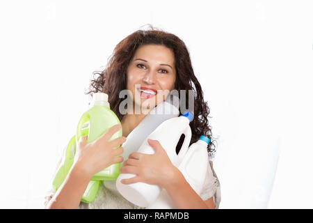 Femme avec de longs cheveux smiling, bouteilles en plastique pour le recyclage. Portrait mais avec du Moyen Orient ou de traits somatiques indien. Banque D'Images