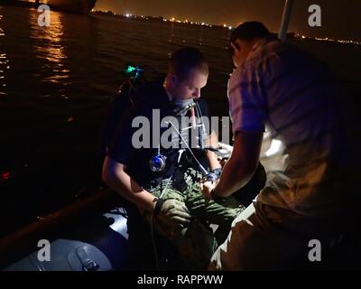 CAMP LEMONNIER, Djibouti (Feb.23, 2017) Le lieutenant j.g Riley dures et de neutralisation des explosifs de la classe de 3ème Technicien James McKnight, assigné à la Force de Sparte, conduite chef de plongée vérifications avant de s'éclabousser dans le port de Djibouti, le 23 février 2017. États-unis 6e Flotte, basée à Naples, Italie, effectue l'ensemble des opérations navales et mixte, souvent de concert avec ses alliés, le joint, et inter-organismes partenaires, afin de faire progresser les intérêts nationaux américains et la sécurité et la stabilité en Europe et l'Afrique. Banque D'Images