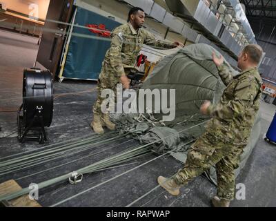 Le sergent de l'US Air Force. Jarryd Dooley, à gauche, et le sergent-major de l'US Air Force. Brian Demik, 352e Escadron d'appui d'opérations spéciales la livraison aérienne de gréeurs, démêler un parachute Le 15 février 2017, sur RAF Mildenhall, Angleterre. Le vol de livraison aérienne utilise des véhicules industriels pour collecter la cargaison après qu'il a été supprimé de l'appareil. Banque D'Images