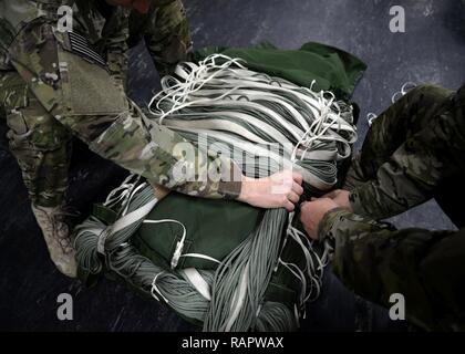 Les commandos de l'air US Air Force du 352e Escadron d'appui d'opérations spéciales la livraison aérienne de fixer un parachute Le 15 février 2017, sur RAF Mildenhall, Angleterre. La livraison aérienne de vol est constitué de trois spécialités de l'Armée de l'air : l'équipage d'arrimeurs, équipement de vol et du transport aérien. Banque D'Images