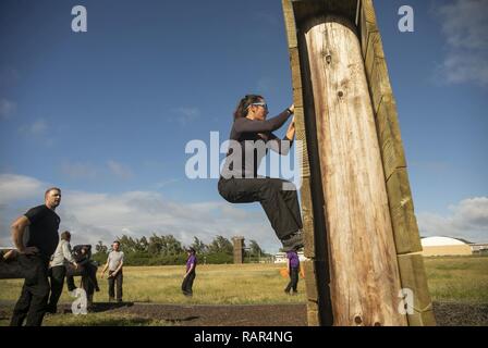 Membre de l'exécutif du Programme de perfectionnement en leadership grimpe sur un mur pendant la course à obstacle à la zone d'Boondocker Base du Corps des Marines, Hawaii, le 11 décembre 2018. Le programme offre des possibilités de perfectionnement du leadership et les adresses les compétences clés des employés à fort potentiel au niveau GS-13 et 14 niveaux ou équivalent dont les plans de carrière : déménagement dans des postes de gestion supérieure. Banque D'Images