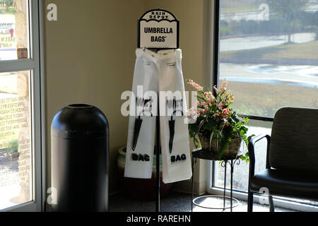 Distributeur de sacs parapluie mouillé ; sacs en plastique pour les parapluies dans un immeuble de bureaux hall. Banque D'Images