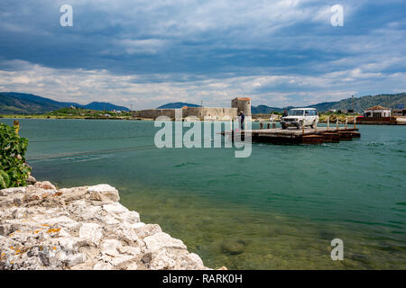 BUTRINT, ALBANIE - 17 MAI 2017 : Les passagers croix avec leur gros SUV blanc voiture sur petit ferry plate-forme en bois au printemps chaud ensoleillée journée. Veneci Banque D'Images