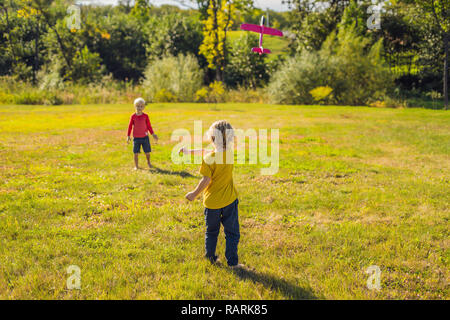 Deux garçons heureux Playing with toy avion dans le parc Banque D'Images