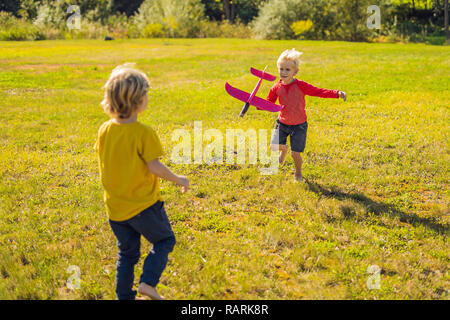 Deux garçons heureux Playing with toy avion dans le parc Banque D'Images