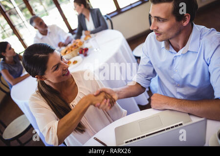 Business people shaking hands in restaurant Banque D'Images