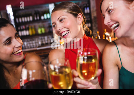 Female friends enjoying wine dans night club Banque D'Images