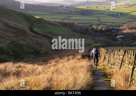 Un vélo de montagne rider sur un Pack Horse Trail au-dessus du village de Calderdale, Lumbutts, West Yorkshire, Angleterre. Banque D'Images