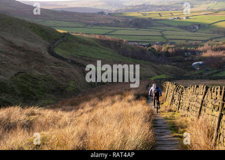 Un vélo de montagne rider sur un Pack Horse Trail au-dessus du village de Calderdale, Lumbutts, West Yorkshire, Angleterre. Banque D'Images