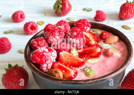 Bol avec berry smoothie fraise, framboise, noix et graines pour déjeuner sain. close up Banque D'Images