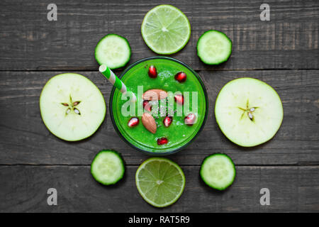 Smoothie vert sain dans un verre de graines de chia, de grenade et de noix avec une paille sur table en bois rustique. vue d'en haut. boisson detox Banque D'Images