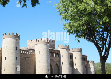 La façade avec des tours et des murs de l'Organisation islamique pour l'Aljaferia forteresse, un ancien château musulman, avec drapeaux, dans un battement d'été ensoleillé, à Saragosse, Espagne Banque D'Images