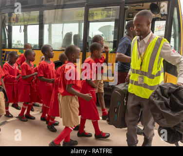 Les garçons et filles en uniforme d'autobus de l'aéroport d'embarquement, l'aéroport d'Entebbe, Ouganda, Afrique du Sud Banque D'Images