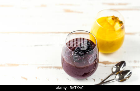 Smoothie aux couleurs jaune et bleu dans deux verres Banque D'Images