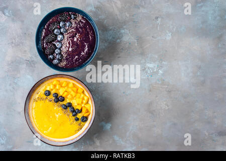 Vue de dessus de deux plaques avec jaune et violet smoothies Banque D'Images