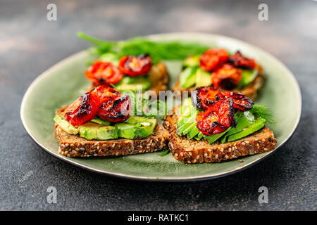 Toasts à l'avocat tomates rôties dans une assiette Banque D'Images