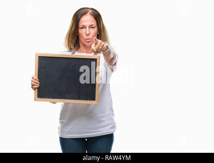 L'âge moyen hispanic woman holding tableau noir sur fond isolé pointant avec le doigt à la caméra et à la main, vous signe, positif et confiant Banque D'Images