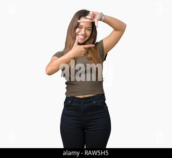 Belle jeune femme brune sur fond isolé du châssis en souriant avec les mains et les doigts avec un visage heureux. La créativité et la photographie concep Banque D'Images