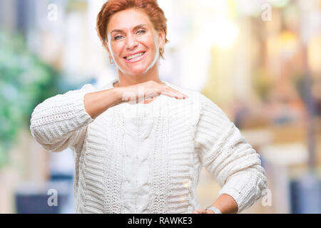 Atrractive redhead caucasian woman wearing winter sweater sur fond isolé gesticulant avec mains montrant grand et de grande taille, mesurant signe Banque D'Images