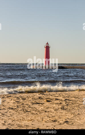 L'une des trois lumières à Muskegon, Michigan. Les vagues se fracassent sur la plage sur une belle journée de la fin de l'automne. Banque D'Images