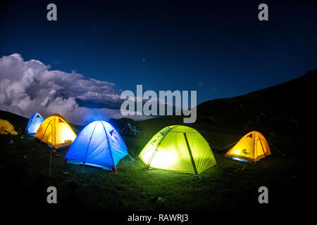 Une rangée de tentes de nuit sur Khalia haut au-dessus de la ville de Munsyari dans Uttarakhand, Inde du nord de l'Himalaya. L'Panchchuli pics dans la distance. Banque D'Images