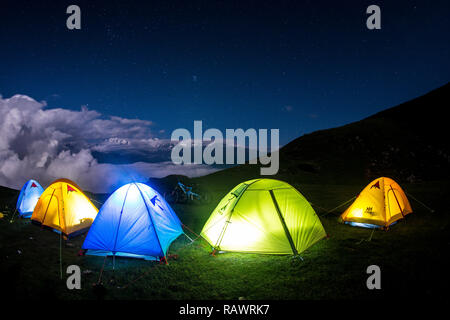 Une rangée de tentes de nuit sur Khalia haut au-dessus de la ville de Munsyari dans Uttarakhand, Inde du nord de l'Himalaya. L'Panchchuli pics dans la distance. Banque D'Images