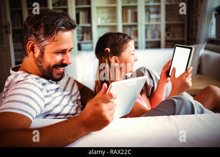 Père et fille using digital tablet in living room Banque D'Images