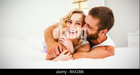 Jeune couple embracing on bed Banque D'Images