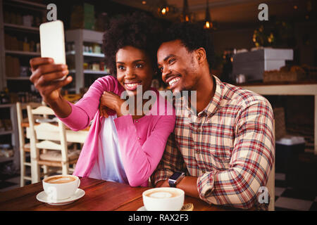 Happy young couple in cafeteria selfies Banque D'Images